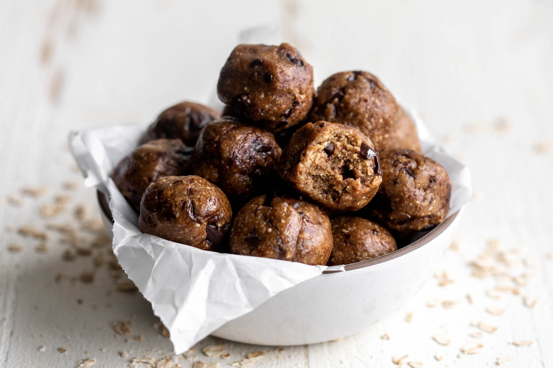 no bake chocolate chip oat energy balls in parchment paper bowl.