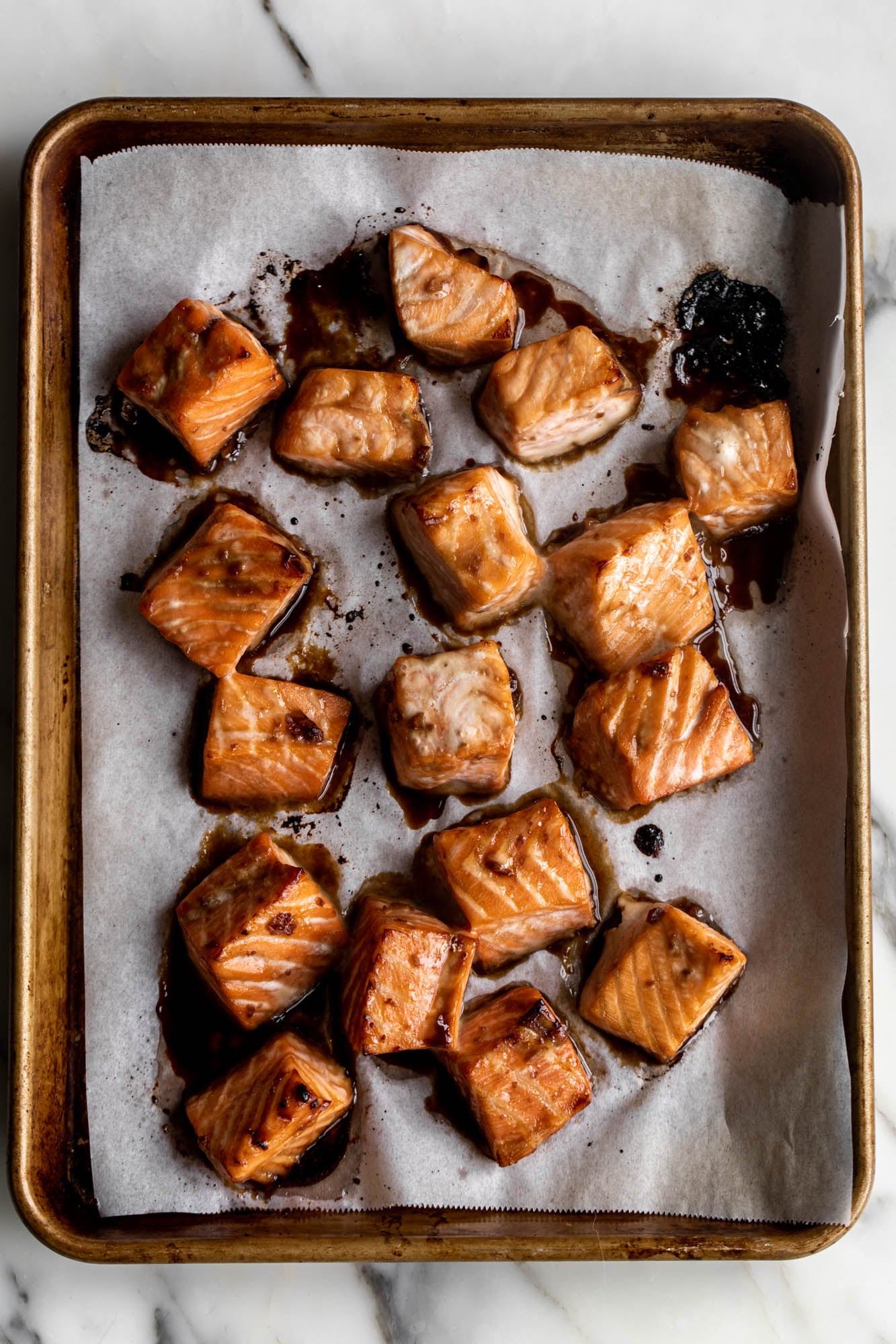 marinated baked salmon in baking pan on parchment paper. 
