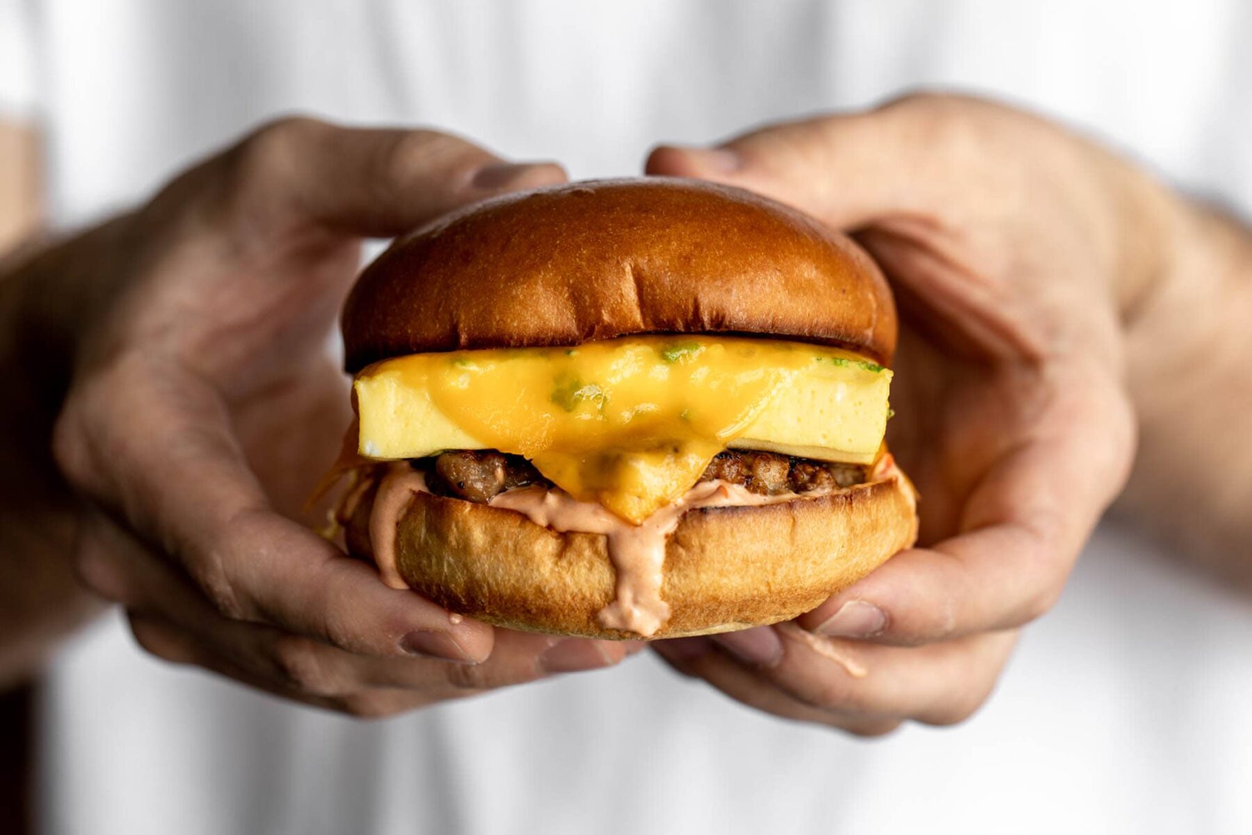 steamed egg patty breakfast sandwich with harissa mayonnaise on a brioche bun.