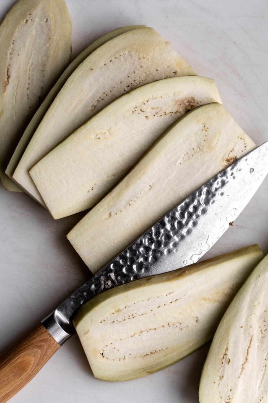 cut eggplant for eggplant parmesan sandwich.