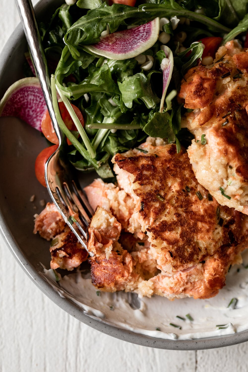 salmon cakes with corn and arugula salad.