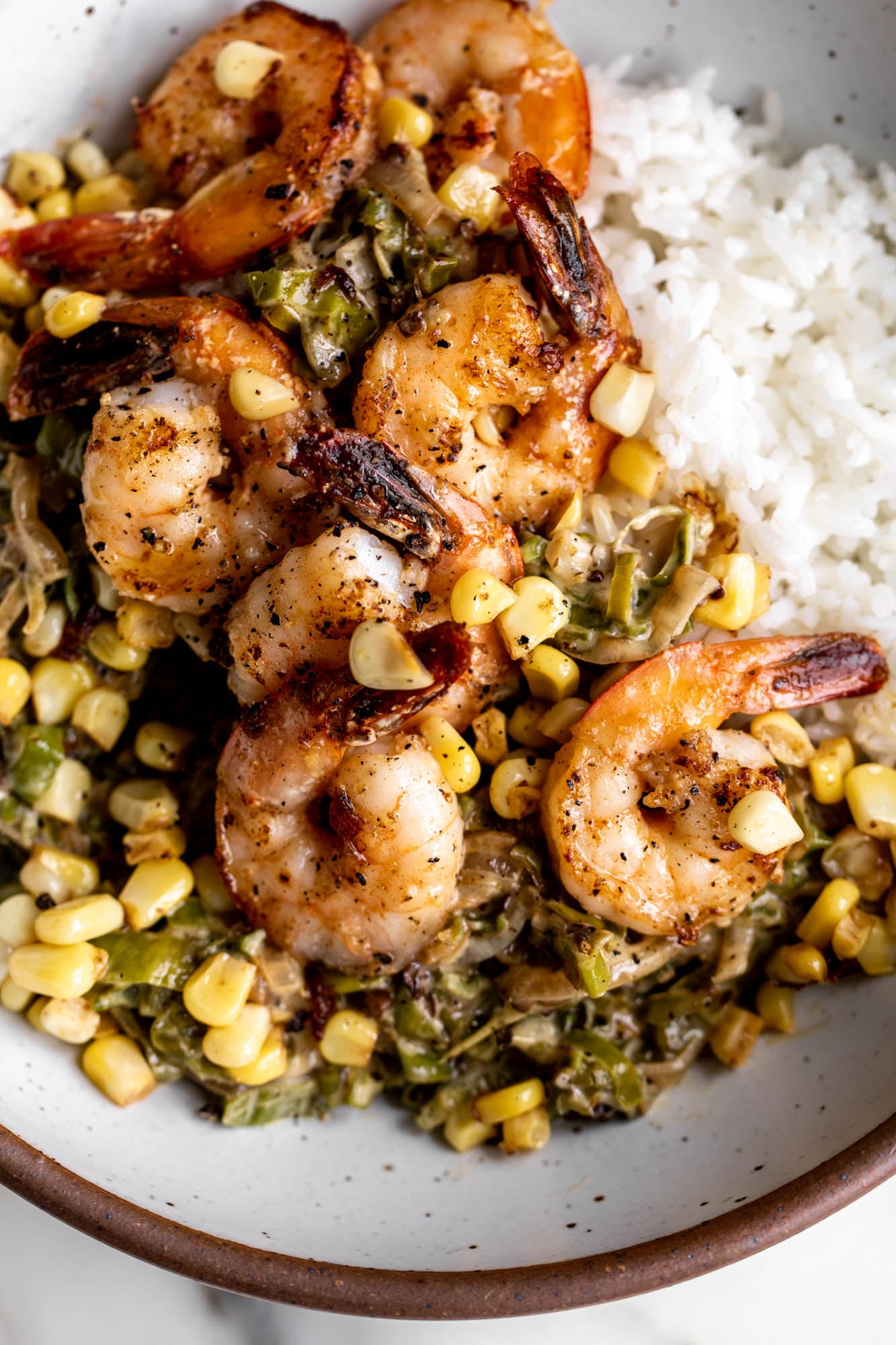 sautéed shrimp with creamed shishitos and corn over rice.