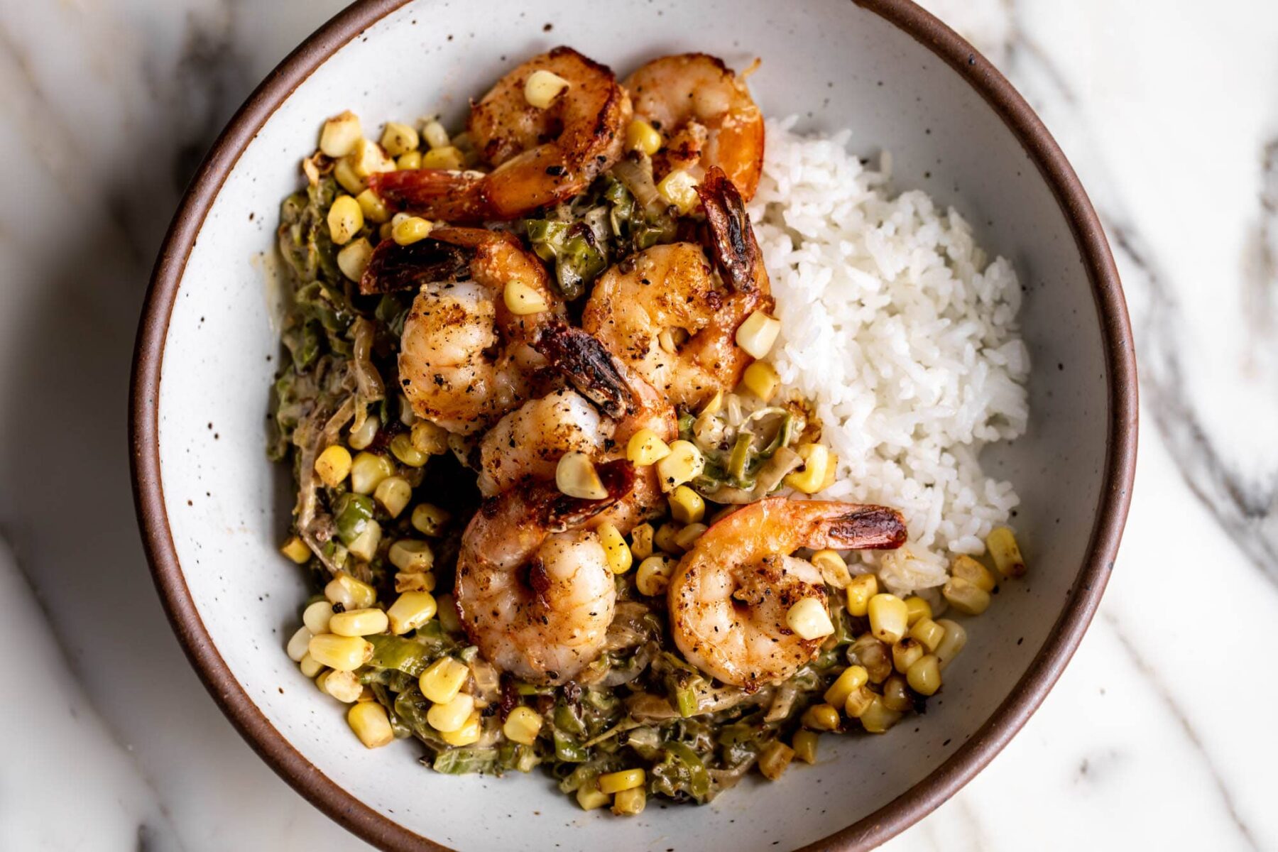 sautéed shrimp with creamed shishitos and corn over white rice.