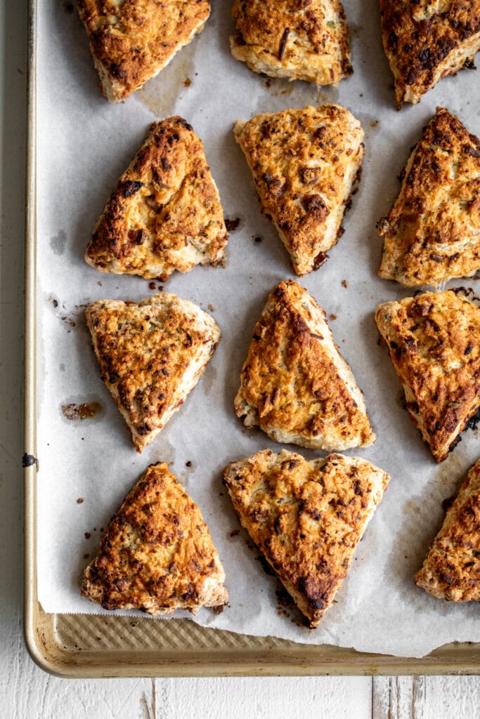 four cheese and sausage scones with hot honey butter glaze on baking sheet golden brown.