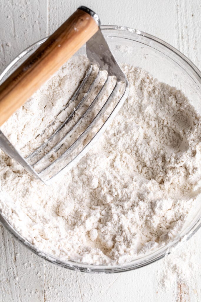 glass mixing bowl with butter cut in in small pieces pastry cutter.