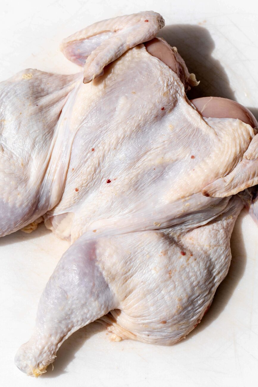 pressed down flattened spatchcocked whole chicken.