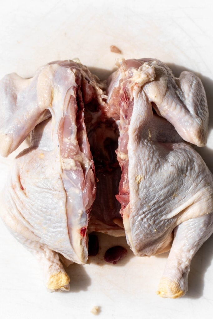 raw whole chicken with backbone removed.