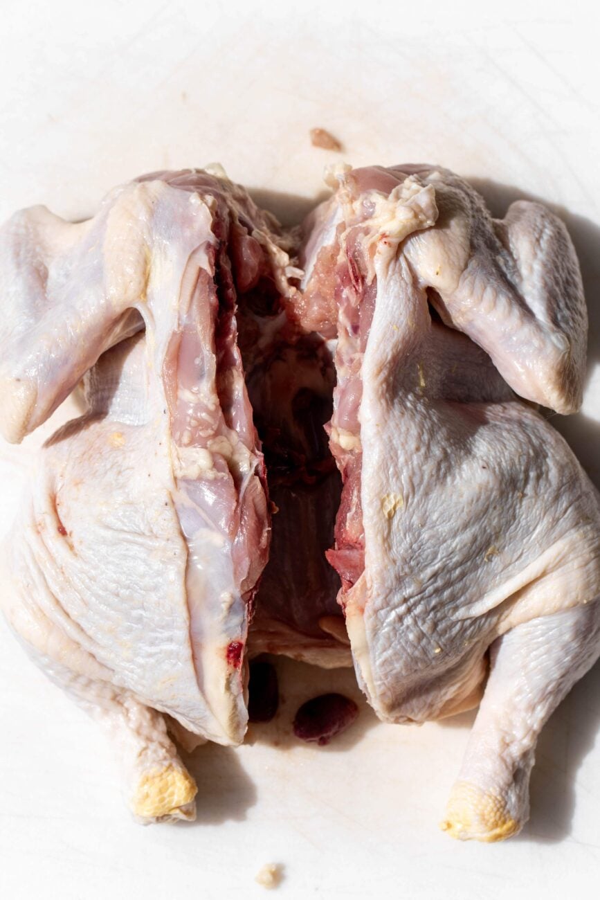 raw whole chicken with backbone removed.