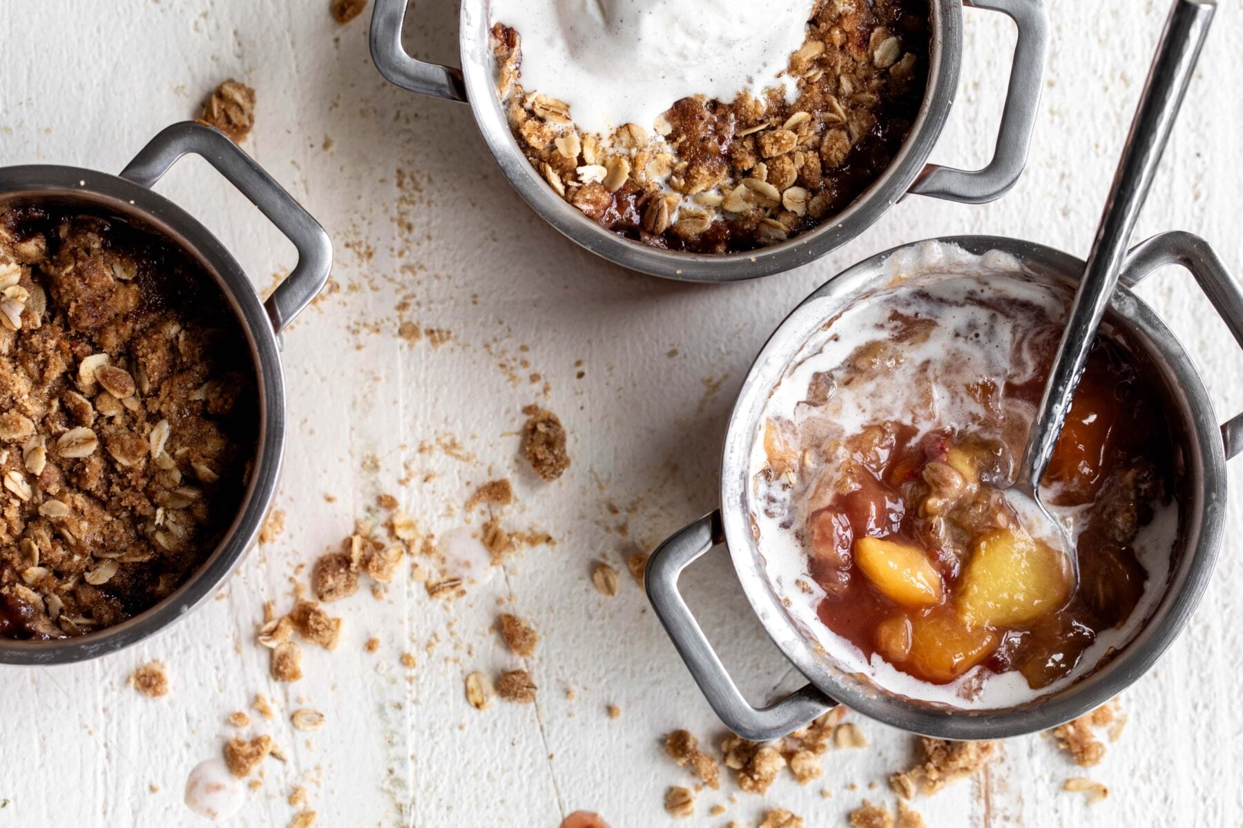 Peach melba crisp with raspberries and vanilla ice cream over oat topping.