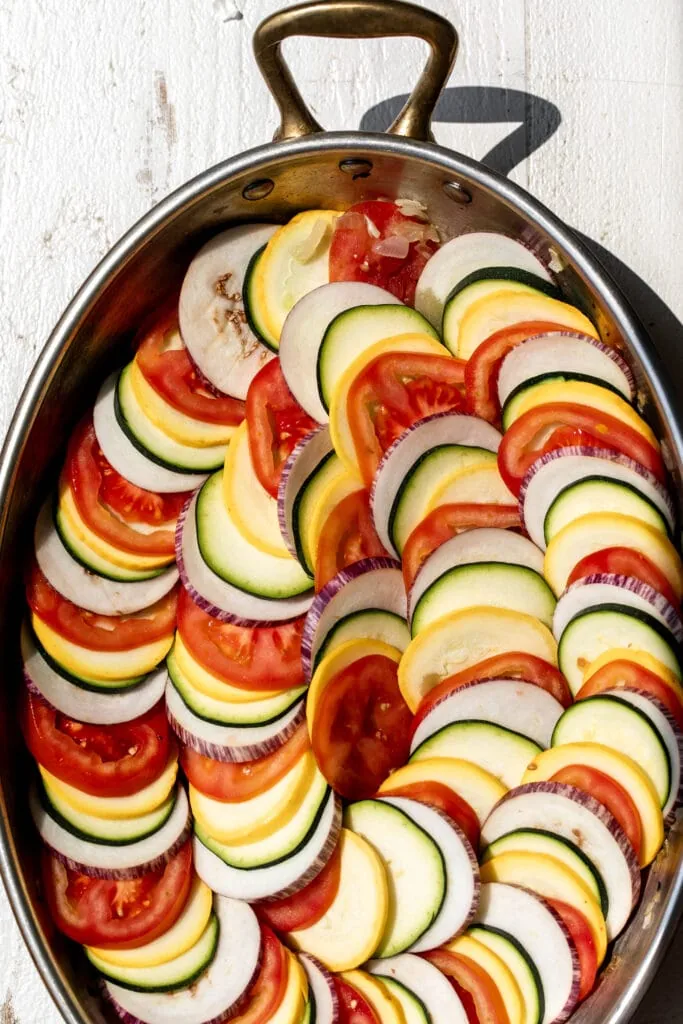 arranged ratatouille gratin ingredients eggplant zucchini summer squash and tomatoes on the vine in swirl