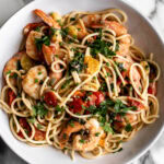 summer shrimp scampi pasta with tomatoes and fresh herbs.