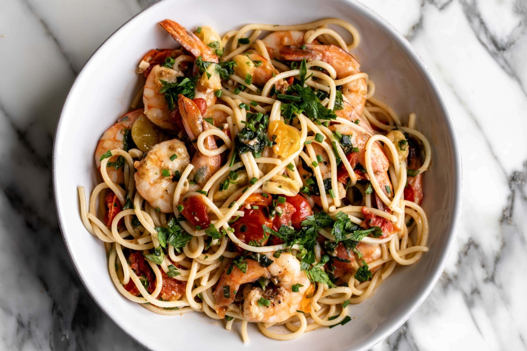 summer shrimp scampi pasta with tomatoes and fresh herbs.
