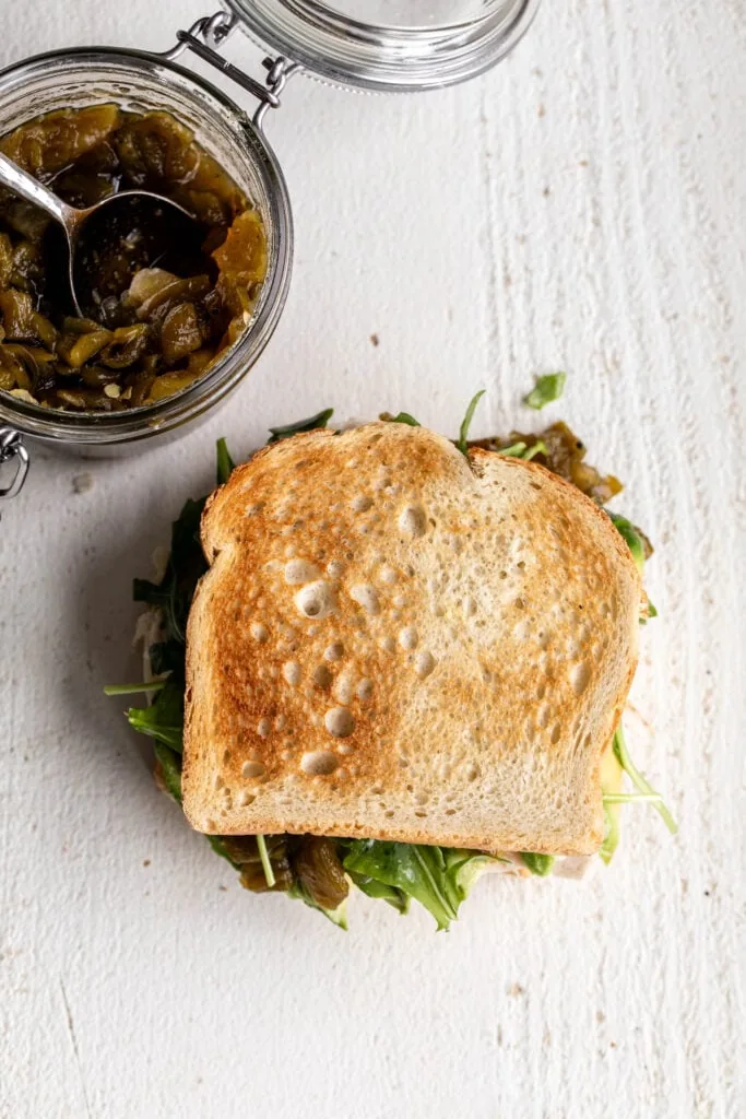 turkey sandwich assembled on white wood background