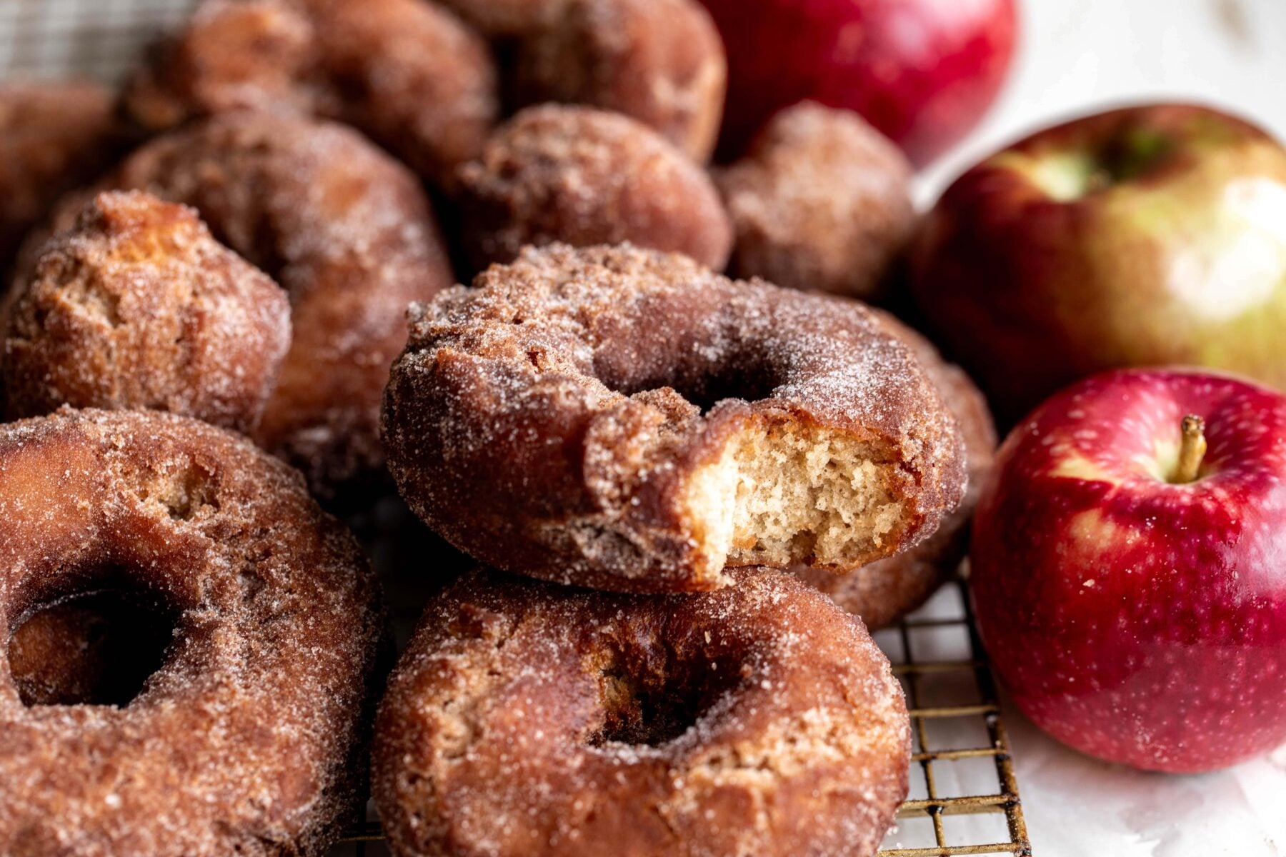 fried apple cider donuts with red apples.
