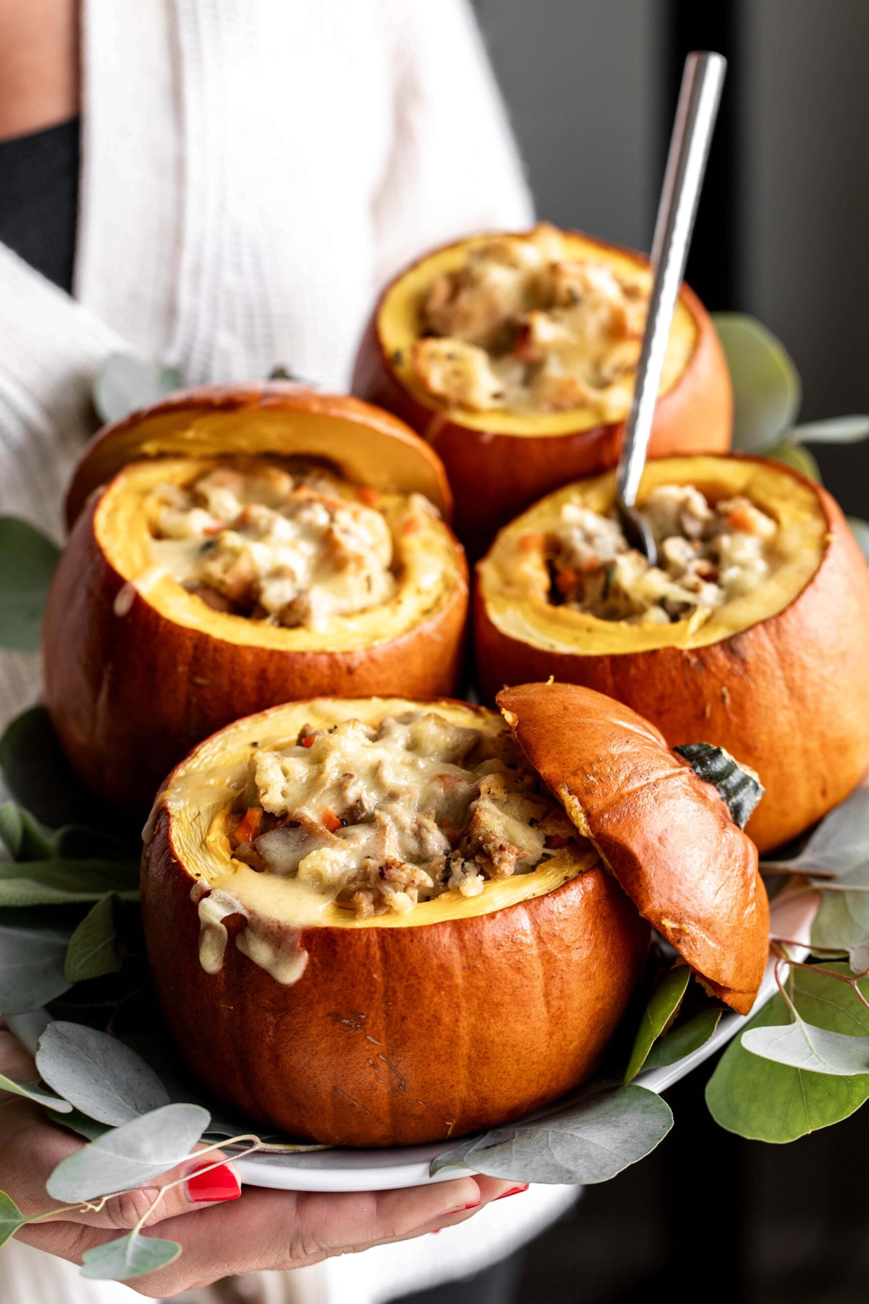Ground Turkey & Brown Butter Sage Stuffing Filled Roasted Mini Pumpkins garnished with eucalyptus and sage.