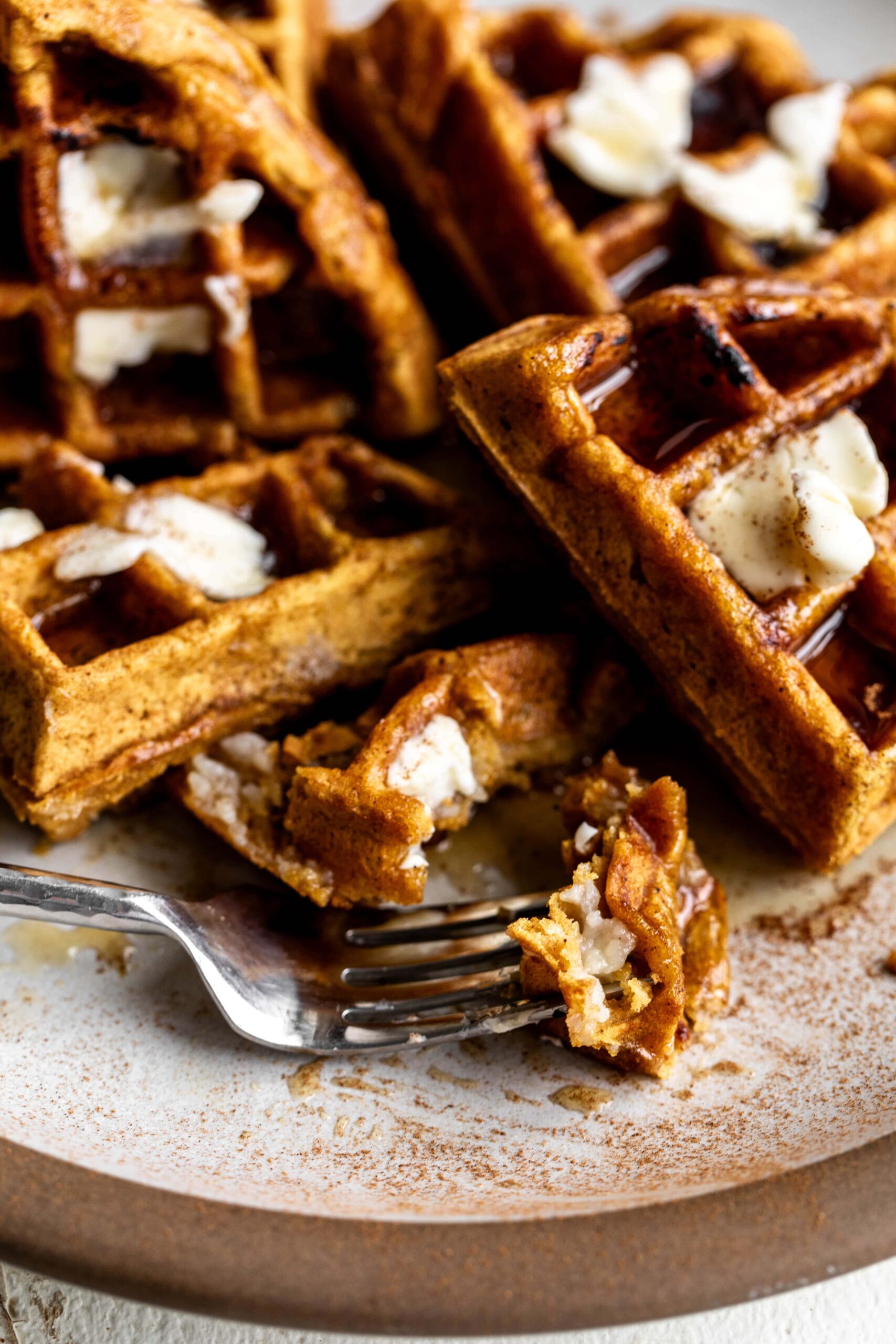 bite on fork pumpkin waffles with cream cheese filling.