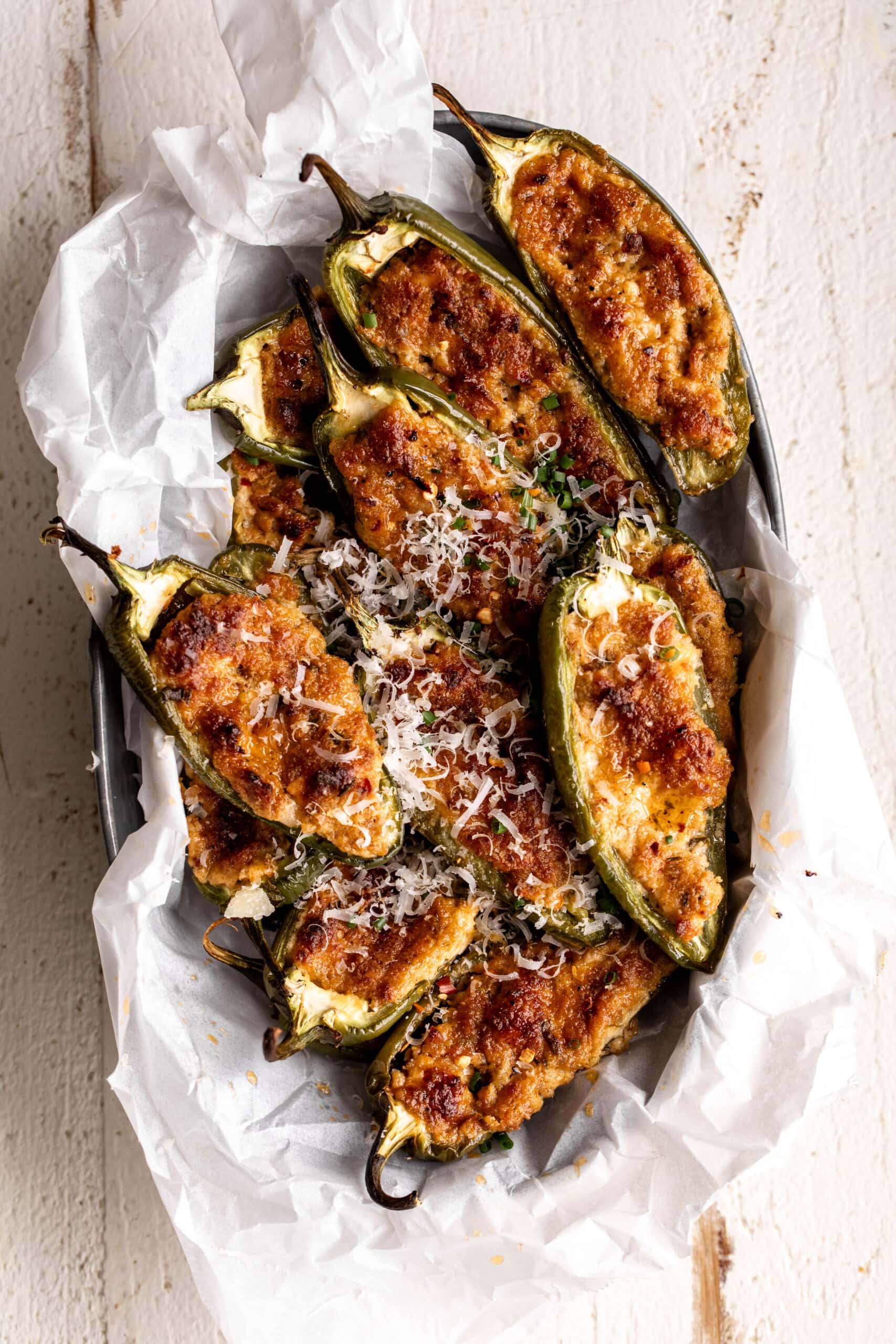 spicy sausage stuffed jalapeno peppers garnished with parmesan cheese.