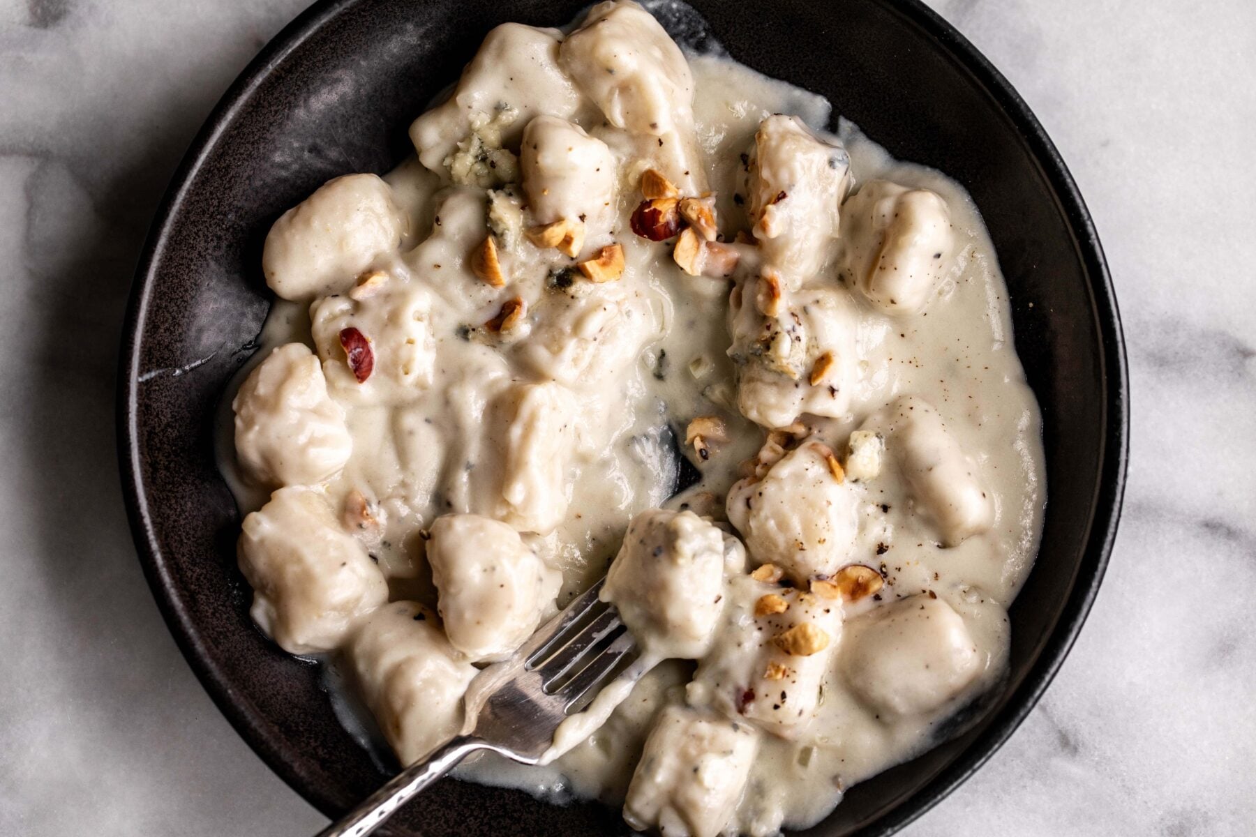 potato gnocchi in blue cheese cream sauce topped with hazelnuts.