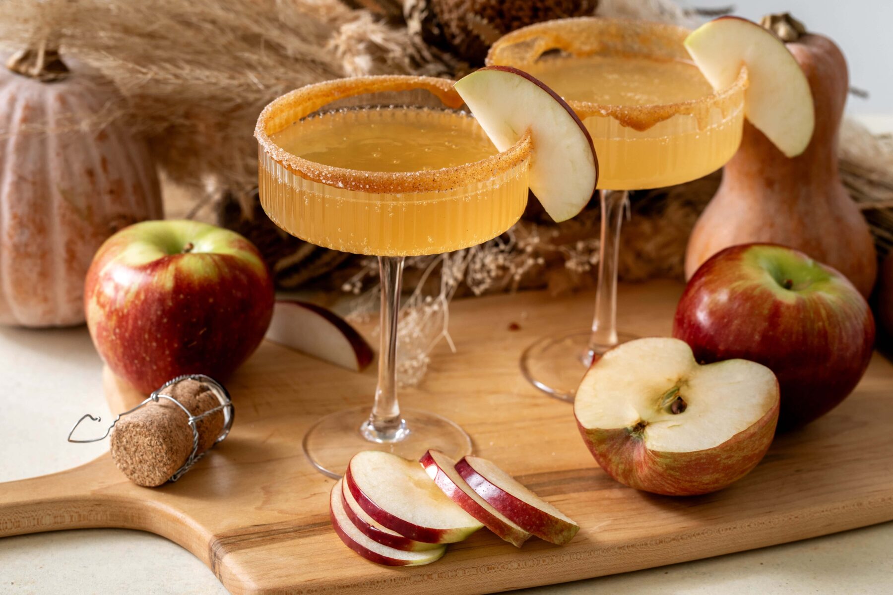Apple cider mimosa autumn cocktail garnished with apple slices.