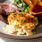 individual cheater cheesy au gratin potatoes garnished with chives.