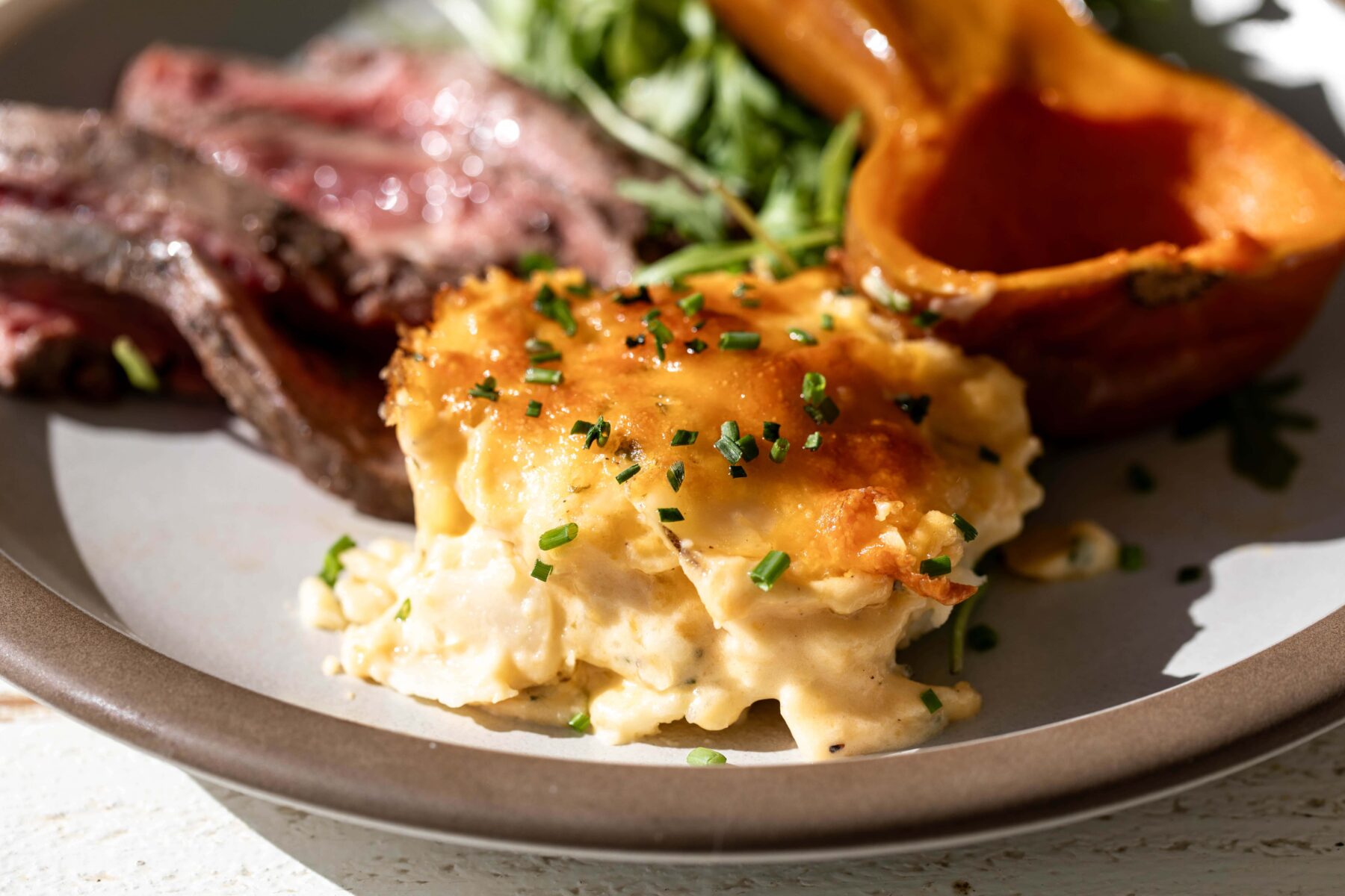 individual cheater cheesy au gratin potatoes garnished with chives.