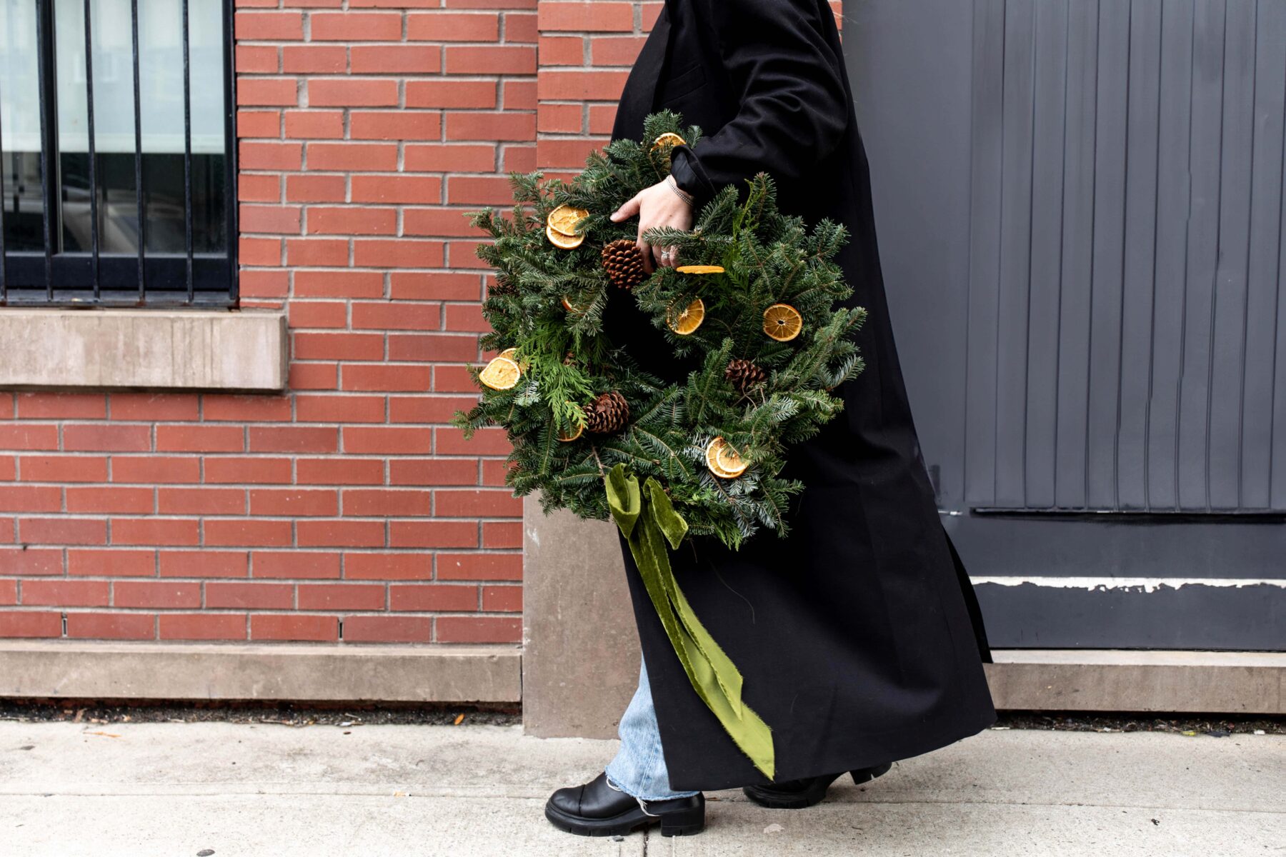 kylie mazon-chambers holding dried citrus embellished christmas wreath.