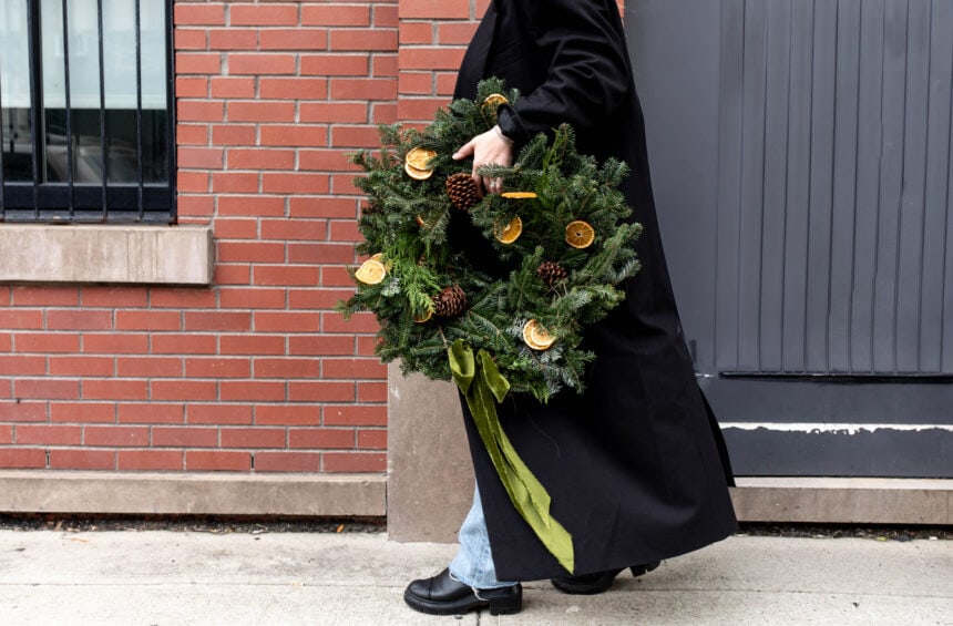 kylie mazon-chambers holding dried citrus embellished christmas wreath.