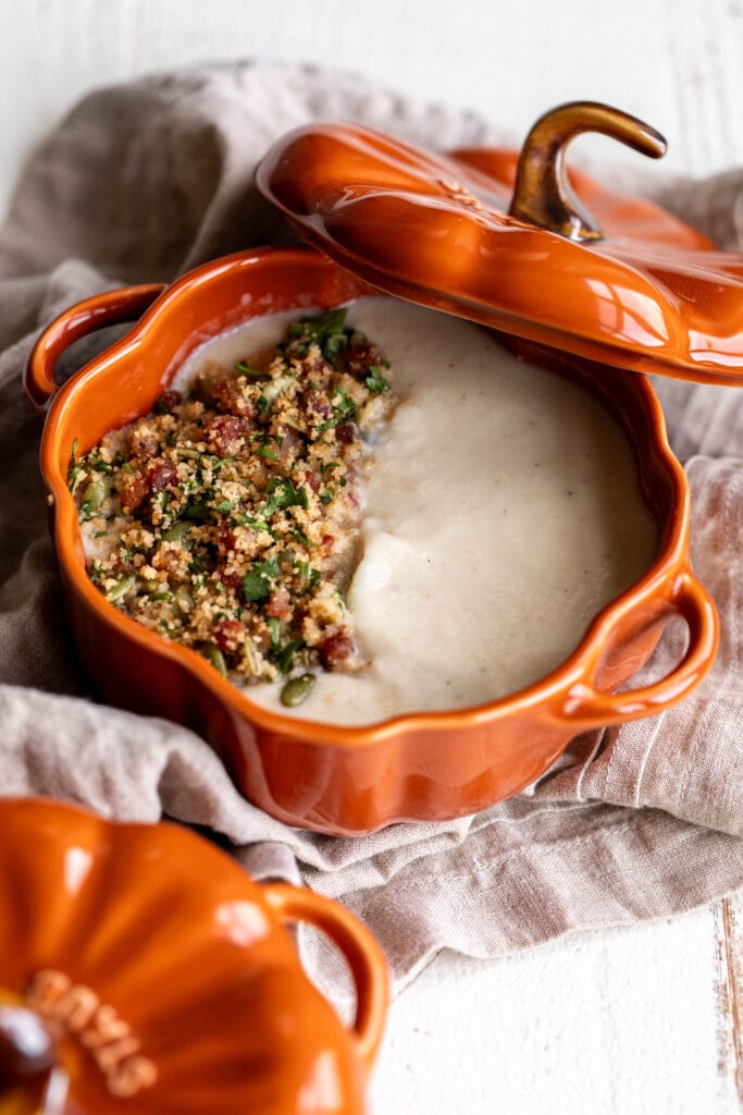 Roasted Garlic Cauliflower Soup with Pancetta and Toasted Breadcrumbs in pumpkin staub cocotte