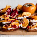 spiced honey persimmon toasts garnished with pomegranate seeds.