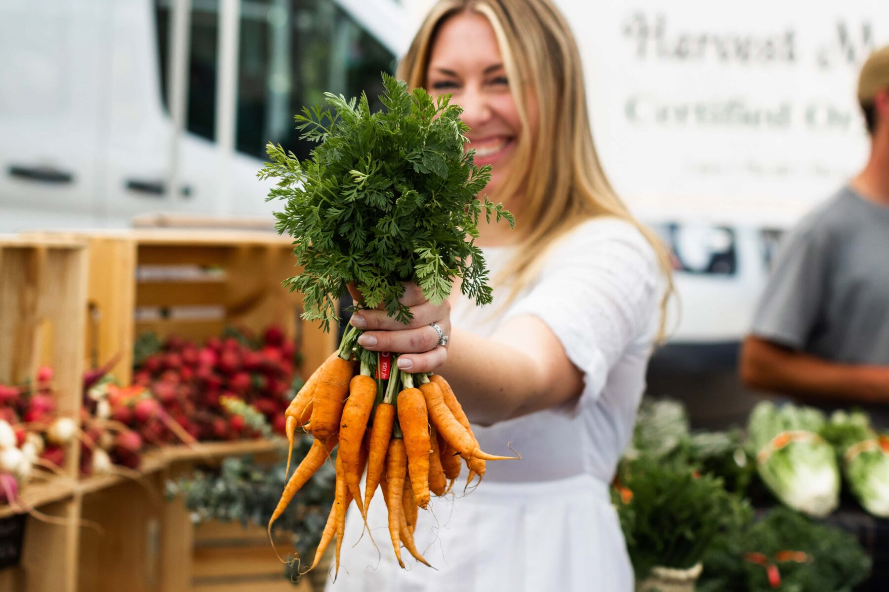 holding farmers market carrots.