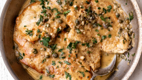easy chicken piccata with butter pan sauce and capers with chopped herbs.