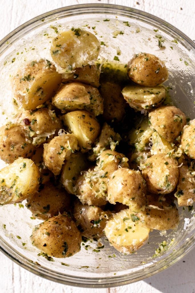 potatoes with pesto in glass mixing bowl.