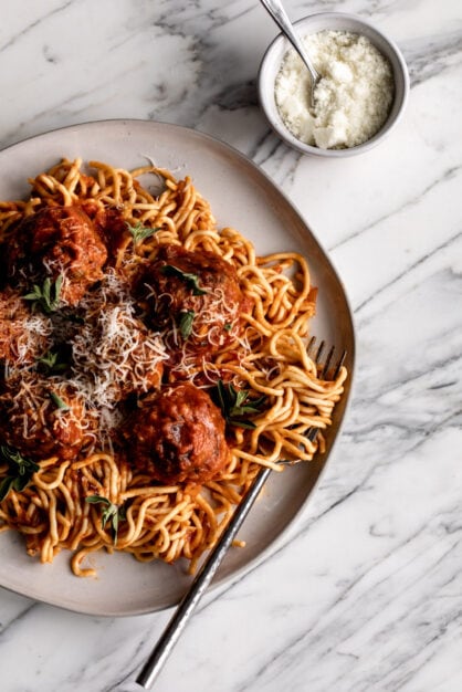 beef pork and prosciutto italian meatballs over spaghetti.