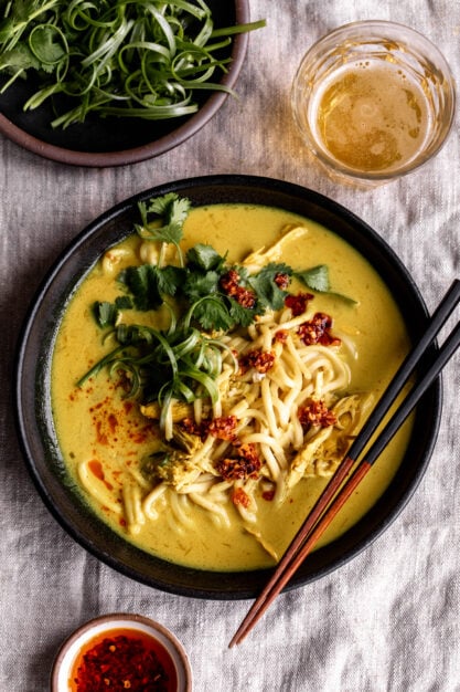 coconut turmeric chicken soup with herbs and noodles.