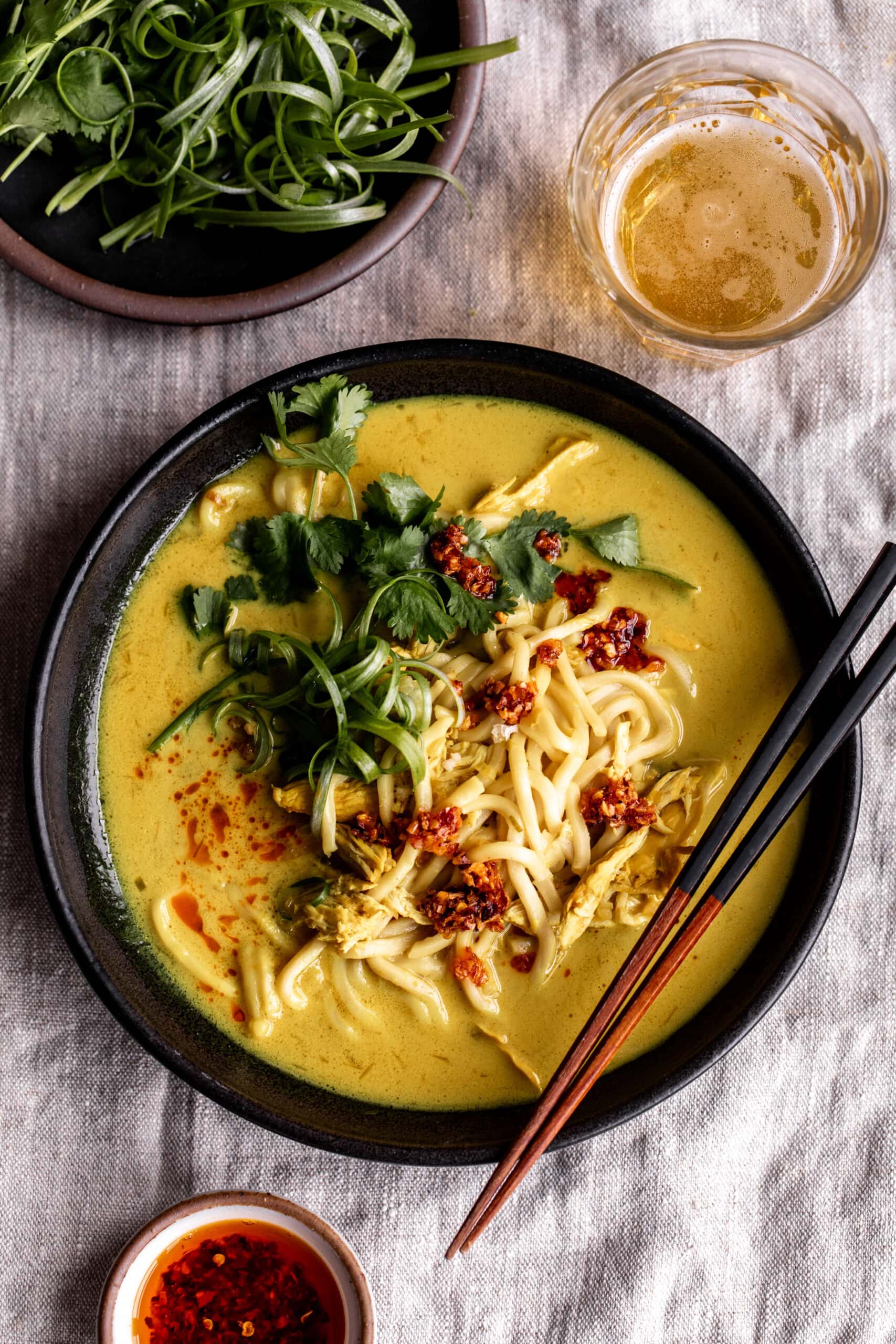 coconut turmeric chicken soup with herbs and noodles.