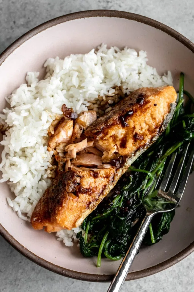 crispy salmon with soy tamarind sauce over spinach and rice