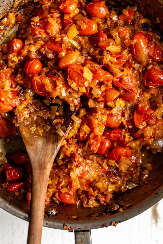 sautéed yellow and red bell peppers and cherry tomatoes in sauté pan.