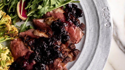 sliced seared duck breast with blueberry pan sauce.