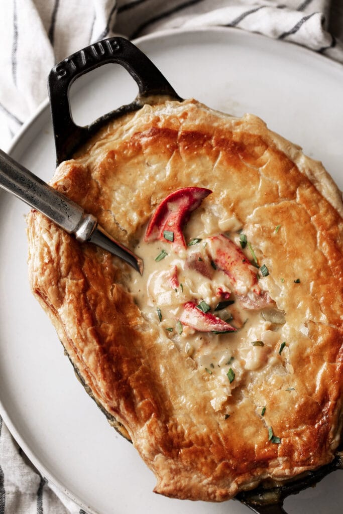 lobster pot pie in individual serving dish with lobster claw meat.