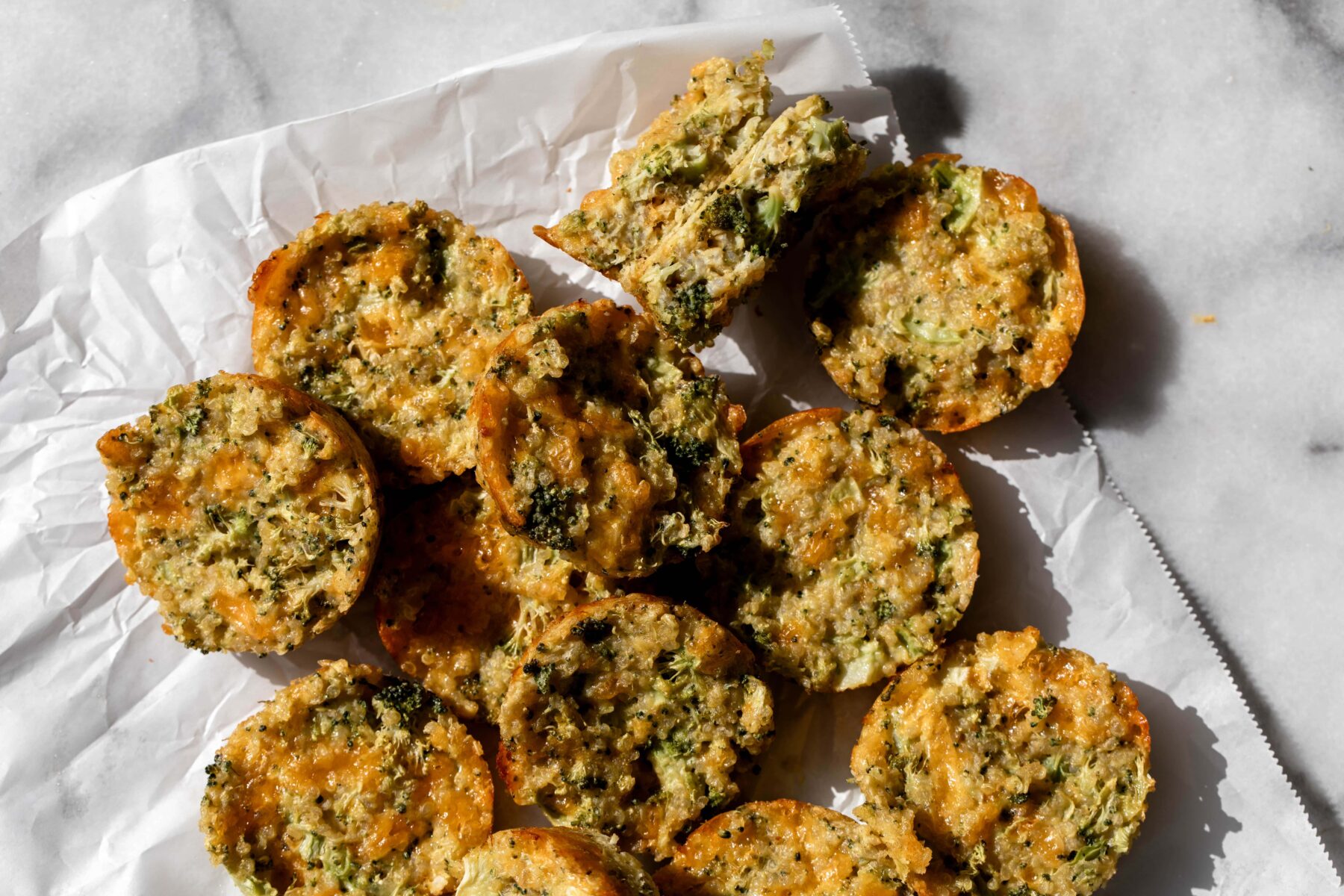 broccoli cheddar quinoa bites on parchment paper.