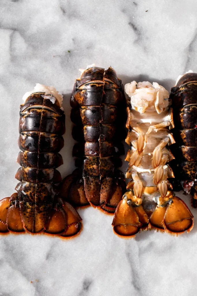 four uncooked lobster tails.