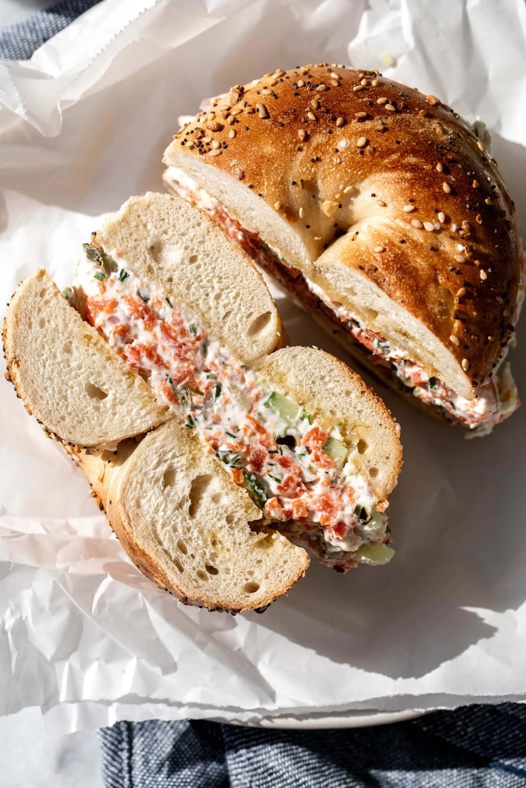 chopped smoked salmon bagel cut in half on parchment paper.