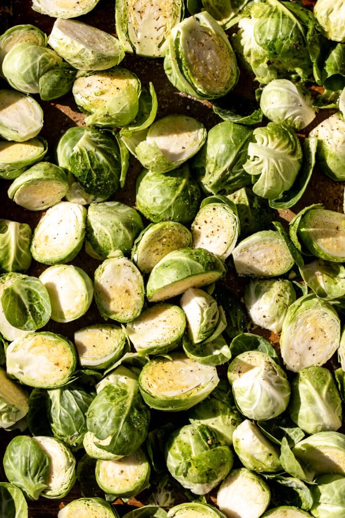 halved brussels sprouts seasoned on baking sheet