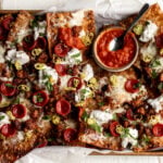 Italian nachos with marinara sauce, pepperoni and sausage on baking sheet.