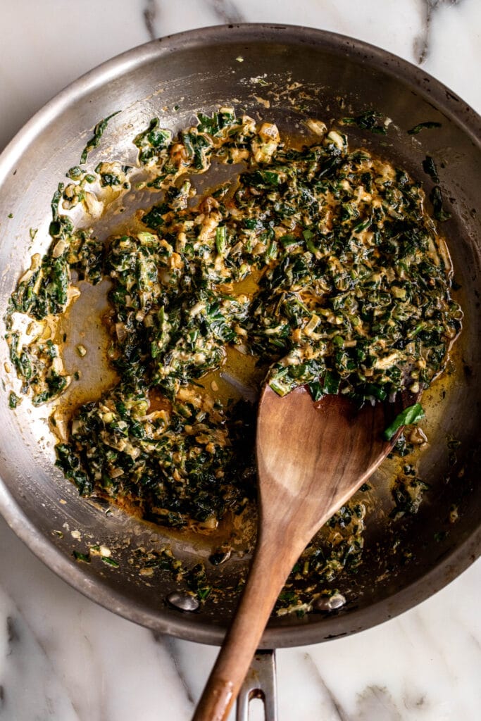 sautéed greens spinach, parsley, green onions, tarragon in sauté pan.