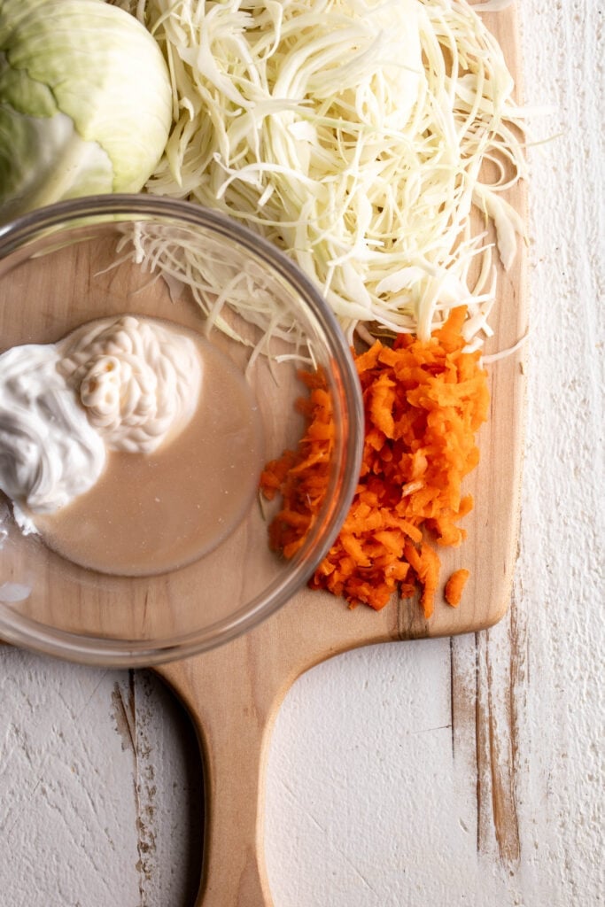 creamy green cabbage and shredded carrot slaw with mayonnaise sour cream and apple cider vinegar.