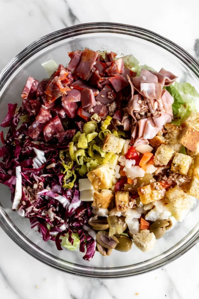 combined salad ingredients in mixing bowl for Muffaletta Salad.