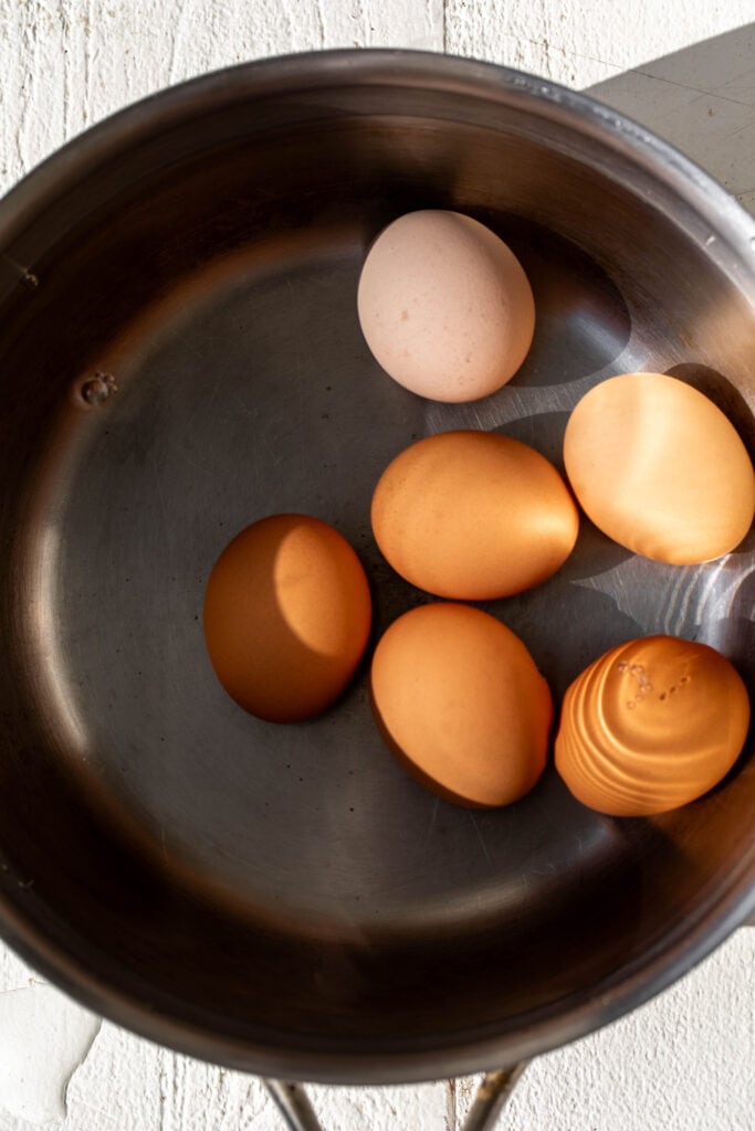 boiled eggs in pot of water.