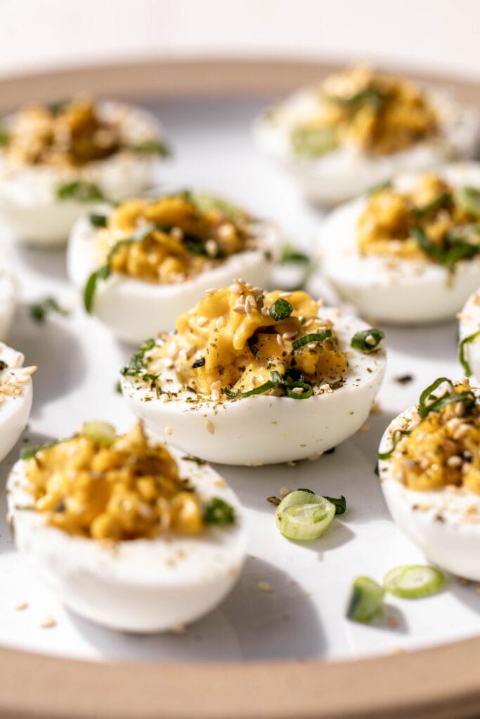 yuzu kosho deviled eggs topped with furikake and diced green onions.