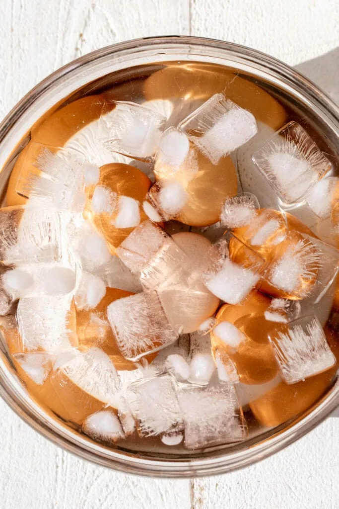 cooled hard boiled eggs in glass bowl filled with ice.